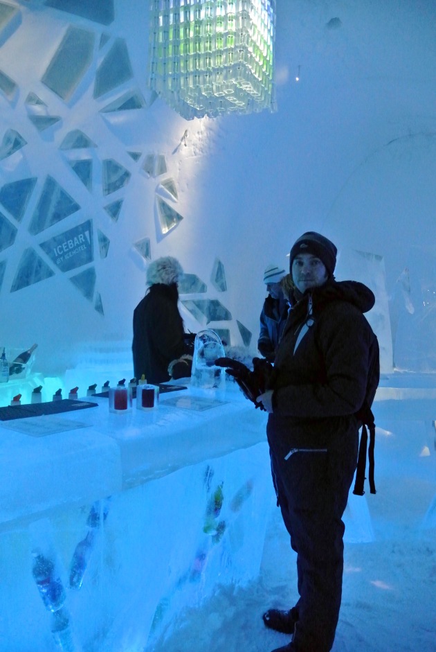 My partner standing at the ICEBAR under the Chandelier made of ICEBAR glasses (over 200)